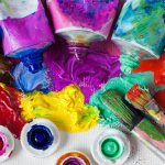Tubes of oil paint, palette and artist paintbrushes closeup.